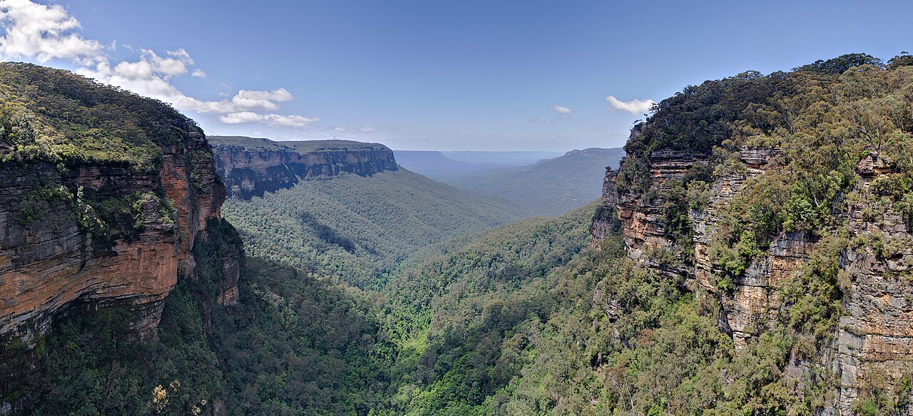 Sweeping valley view with lush vegetation and dramatic cliffs
